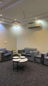 a room with couches and a table with flowers on it at شقة بصالة وغرفة نوم حديثة جازان in Jazan
