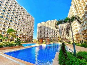 a large swimming pool with two tall buildings at Zayd's Place in Basbas