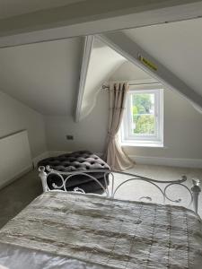 a bedroom with a bed and a window at Upper Rockdale High St Abersoch in Abersoch