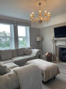 a living room with a couch and a chandelier at Upper Rockdale High St Abersoch in Abersoch