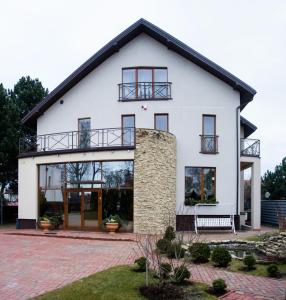 a white house with a black roof at Po Jūros Banga in Palanga
