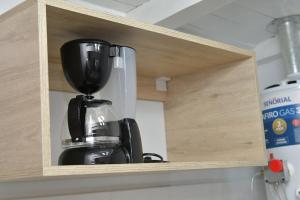 a black coffee maker sitting inside of a cupboard at Apart Lugones Studio in San Rafael