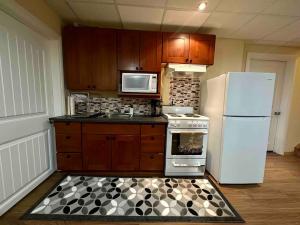 a kitchen with a white refrigerator and a stove at Spacious and beautiful lower Apartment in Chestermere