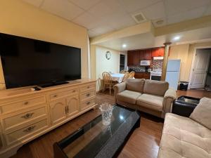 a living room with a large flat screen tv at Spacious and beautiful lower Apartment in Chestermere