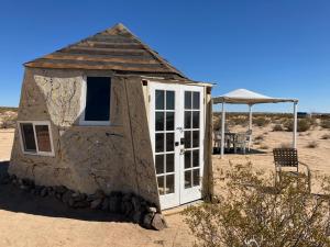 a small shack in the middle of the desert at The Dome at Tribal Camp in Joshua Tree