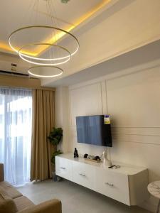 a living room with a flat screen tv and a couch at Cozy 1 bedroom at BE Residences Condominium with balcony near IT Park in Tabok