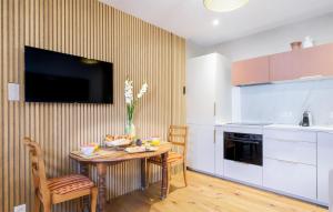 a kitchen with a table and a television on a wall at Superbe Maison Avec Piscine in Parentis-en-Born