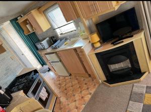an overhead view of a kitchen with a television and a fireplace at Kings Caravan Park A-56 in Chapel Saint Leonards