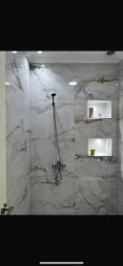 a bathroom with a shower with marble walls and a shower at Ichrak in Nador