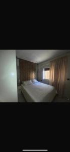 a bedroom with a white bed and a window at Ichrak in Nador