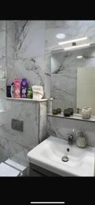 a white bathroom with a sink and a mirror at Ichrak in Nador