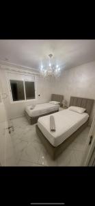a large white room with a bed and a chandelier at Ichrak in Nador