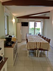 a kitchen with a table and some chairs and a kitchen with a table at Maison du Sacre-Coeur in Lourdes