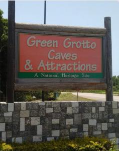 a sign for a green tropico caves and attractions at Jamaica Coastal Getaway in Discovery Bay +2 photos