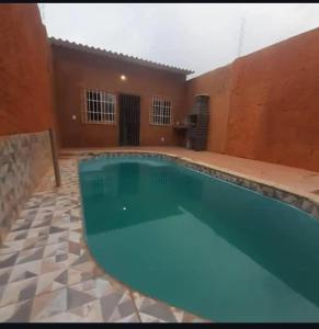a large swimming pool in a courtyard with a house at Hospedaria Km 20 da Br 040 Luziânia in Luziânia