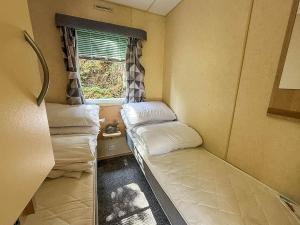 a small room with two beds and a window at Cosy Dog Friendly Caravan, Near To Great Yarmouth In Norfolk Ref 10029Rp in Belton +12 photos