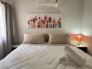 a white bed in a bedroom with a painting on the wall at Acogedor apartamento minimalista Mai in Puerto Vallarta