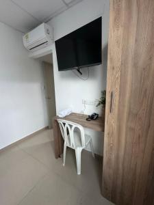 卡塔赫纳Hotel Ibiza Hotel en Cartagena de indias, sector comercial的客房设有一张桌子、一台电视和一把椅子