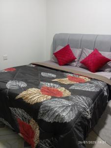 a bed with a black and red quilt on it at SR Sireh Residence in Kota Bharu