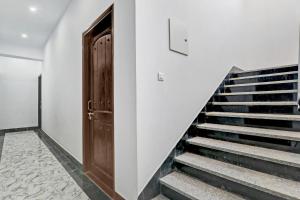 a stairway with a wooden door and a stair case at Hotel O The Lemongrass in Colonelganj