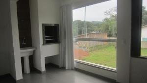 a room with a window with a view of a yard at Residencial Marbella in Bombinhas