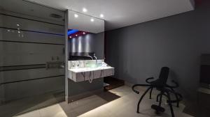 a bathroom with a sink and a chair next to a shower at Motel Lunary in Piedade +14 photos