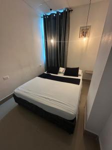 卡塔赫纳Hotel Ibiza Hotel en Cartagena de indias, sector comercial的一间有窗户的小房间里的一张床