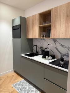Una cocina con gabinetes de madera y un refrigerador negro. en Riviera Luxe Sol, en Sestri Levante