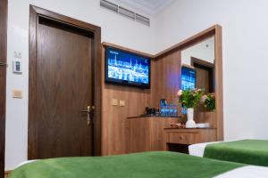Habitación con 2 camas y puerta con TV en Hayah Plaza Hotel, en Medina