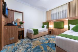 Una habitación de hotel con dos camas y un televisor. en Hayah Plaza Hotel, en Medina