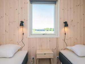 two beds in a small room with a window at 5 star holiday home in Grenaa in Brøndstrup