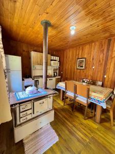 a kitchen with a stove and a table in a room at Casa De Temporada Pé da Serra dos Bitus in Urubici
