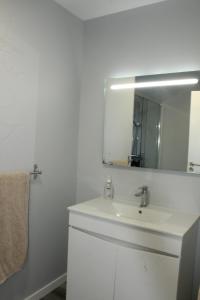 Un baño blanco con lavabo y espejo. en Nature Apartment 2 with Pool, en Arco da Calheta