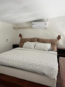 een slaapkamer met een groot bed met twee kussens bij Phimai Pond House in Phimai