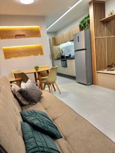 a living room with a couch and a kitchen at Apto novo perto da UFF e Plaza in Niterói