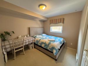 a small bedroom with a bed and a table at Saskatoon Lashyn Cove Homestay in Saskatoon