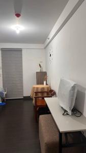 Il comprend un salon doté d'un canapé et d'une table avec une télévision. dans l'établissement Ica JM Nest at Hacienda Balai, à Manille