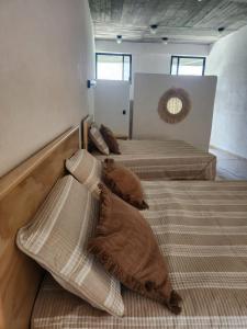 three beds in a room with pillows on them at Casa Nuestra Hotel Boutique y Experiencias para Compartir in Malinalco