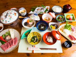 una mesa de madera con platos de comida. en Yufunoyado Kifu, en Yufu