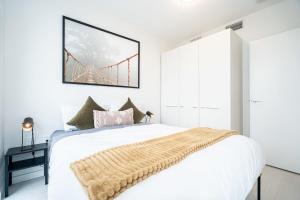 a bedroom with a bed with a bridge painting on the wall at Modern Condo with AC Gym and Parking near Olympic Village for 5 in Vancouver