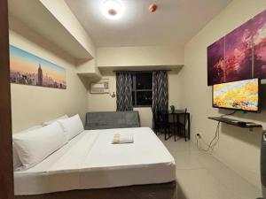 un salon avec un grand lit blanc et une télévision à écran plat dans l'établissement Cebu - HORIZON 101 CONDO RENTAL, à Cebu 4 autres photos