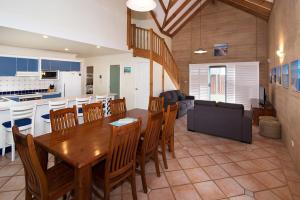 a kitchen and living room with a wooden table and chairs at Tresco, Town central-beach end in Dunsborough +3 photos