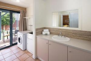 a bathroom with a sink and a washing machine at Tresco, Town central-beach end in Dunsborough