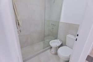 a bathroom with a toilet and a glass shower at Dpto Belgrano II - Santa Fe in Santa Fe +11 photos