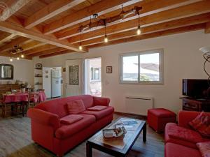 un soggiorno con un divano rosso e un tavolo di Gîte 4 pers, terrasse & jardin, près des Bois Noirs - FR-1-496-348 a Saint-Priest-la-Prugne