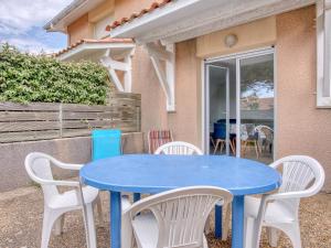 ein blauer Tisch und weiße Stühle vor einem Haus in der Unterkunft Maison T3 proche plage & centre-ville avec jardinet et parking - FR-1-521-200 in Biscarrosse