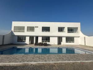 a house with a swimming pool in front of it at RELAX Y PISCINA con vista al MAR - FLAT in Cerro Azul