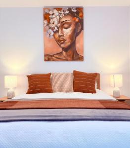 a bedroom with a large bed with a painting on the wall at New High Floor Apartment in the heart of Canberra in Canberra