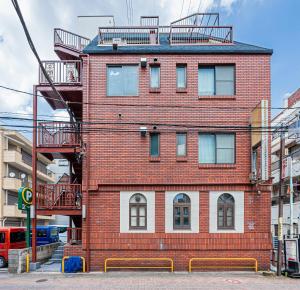 Un edificio de ladrillo rojo con escaleras en la parte superior. en 67Apt Shinkoiwa, en Tokio