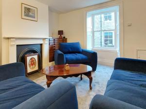 a living room with blue couches and a coffee table at Gilmore House in Alston